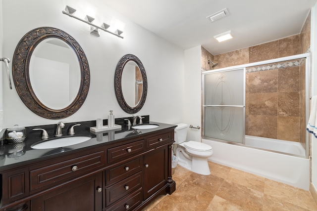 full bathroom featuring tile patterned floors, vanity, bath / shower combo with glass door, and toilet