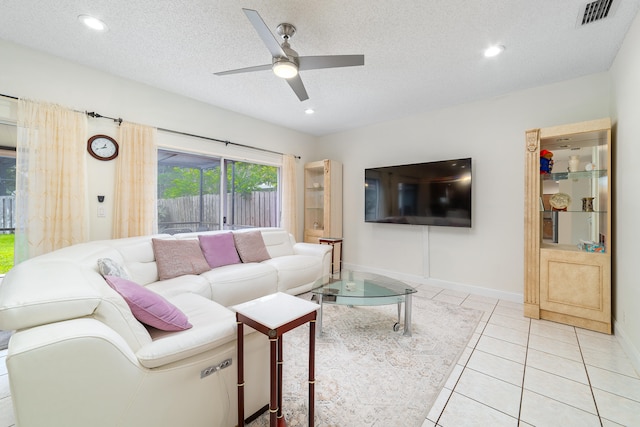 tiled living room featuring ceiling fan and a textured ceiling