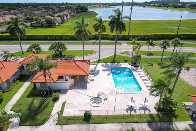 view of pool with a yard, a patio, and a water view