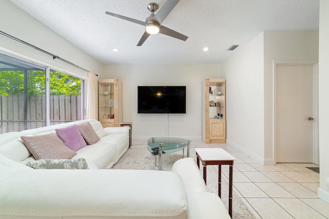 tiled living room with a textured ceiling and ceiling fan