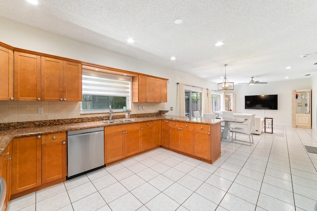 kitchen featuring stainless steel dishwasher, sink, light tile patterned floors, dark stone counters, and kitchen peninsula