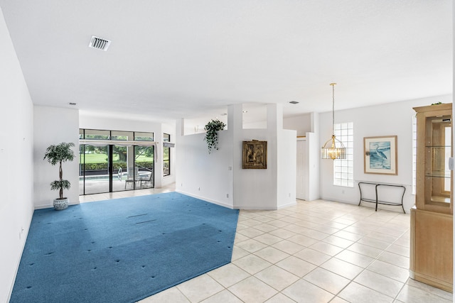 empty room featuring light tile patterned floors, visible vents, and baseboards