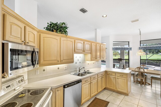 kitchen with decorative backsplash, appliances with stainless steel finishes, light tile patterned floors, sink, and kitchen peninsula