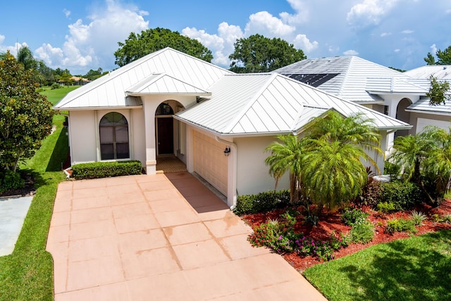 view of front facade featuring a standing seam roof, metal roof, and stucco siding