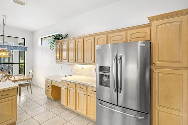 kitchen featuring decorative backsplash, stainless steel fridge with ice dispenser, hanging light fixtures, light countertops, and light brown cabinets