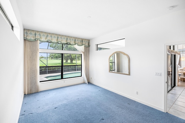 empty room featuring light carpet and baseboards