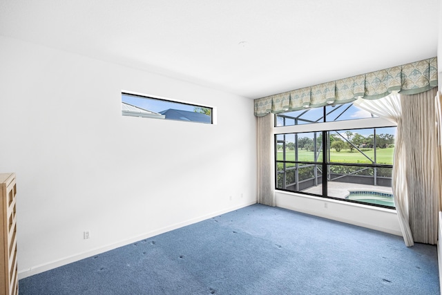 spare room featuring carpet floors and baseboards