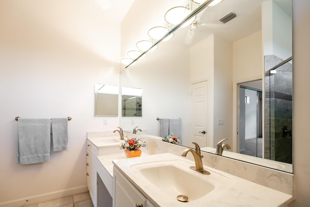 bathroom featuring a stall shower, tile patterned flooring, a sink, and double vanity