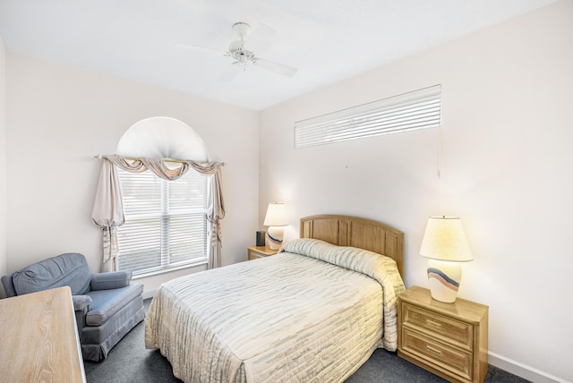 bedroom with baseboards, dark carpet, and a ceiling fan