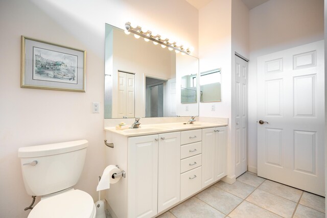 bathroom featuring tile patterned flooring, double sink vanity, and toilet