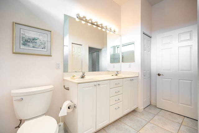 full bathroom with toilet, a sink, a closet, tile patterned floors, and double vanity