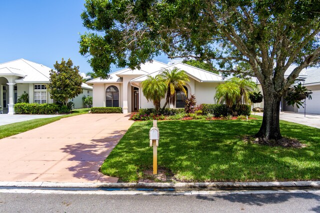 view of front of house with a garage and a front lawn