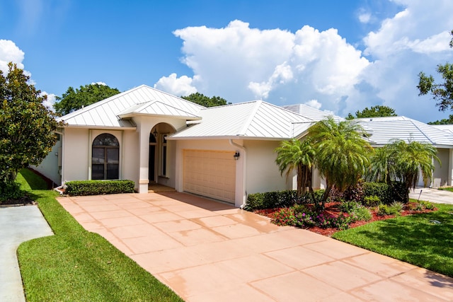 view of front of property featuring stucco siding, concrete driveway, a standing seam roof, metal roof, and a garage