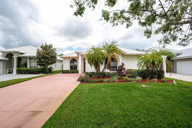 view of front of house featuring a front yard, metal roof, driveway, and stucco siding