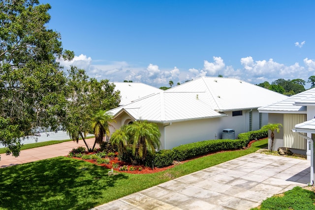 view of side of property featuring concrete driveway, a yard, and stucco siding