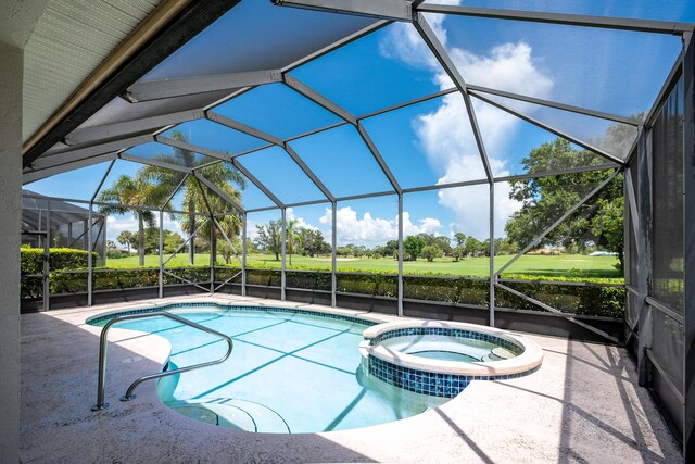 view of swimming pool with an in ground hot tub, glass enclosure, and a patio area