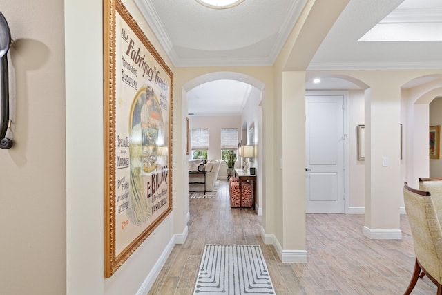 corridor with light hardwood / wood-style floors and ornamental molding