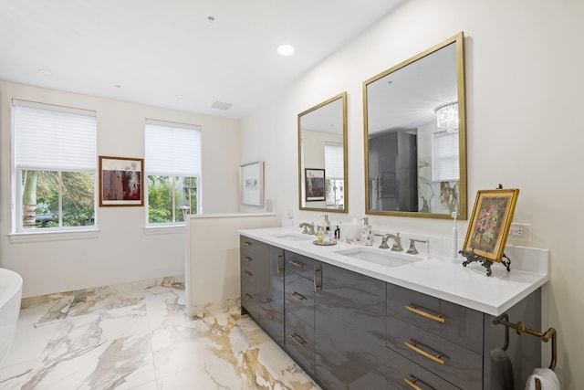 bathroom with a bathtub, double sink vanity, and tile patterned flooring