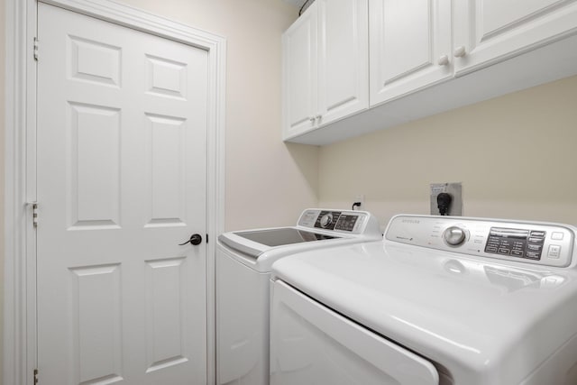 laundry area featuring washer and clothes dryer and cabinets