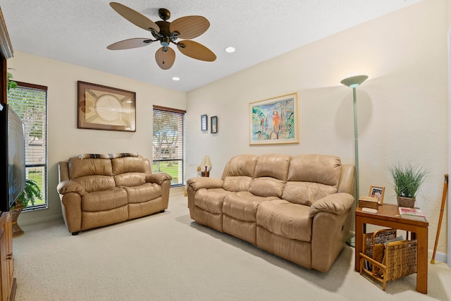 living room featuring ceiling fan, a healthy amount of sunlight, and light colored carpet