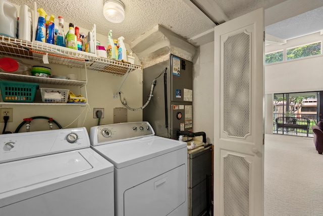 clothes washing area with a textured ceiling, carpet, and washer and clothes dryer