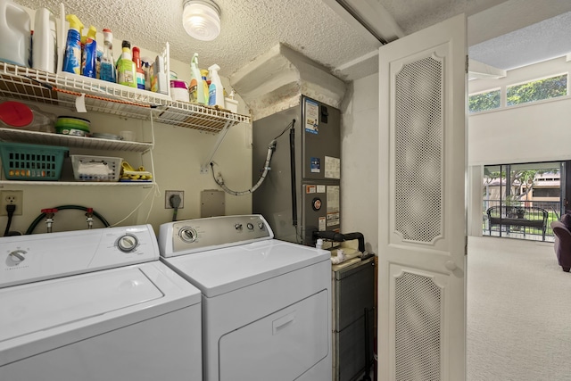 clothes washing area with laundry area, heating unit, a textured ceiling, carpet flooring, and washing machine and dryer