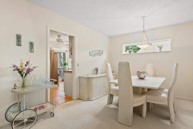 carpeted dining space featuring ceiling fan and a textured ceiling