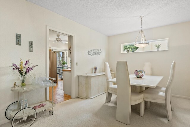 dining area featuring a textured ceiling and light colored carpet