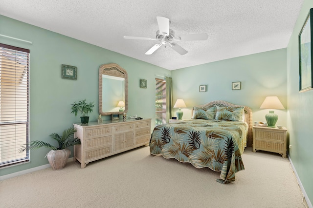 carpeted bedroom featuring a textured ceiling, ceiling fan, and multiple windows