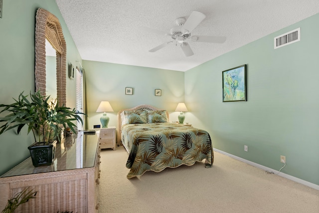 bedroom featuring a textured ceiling, ceiling fan, and light carpet