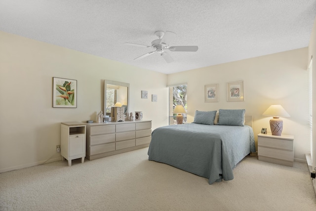 bedroom featuring a ceiling fan, light carpet, a textured ceiling, and baseboards