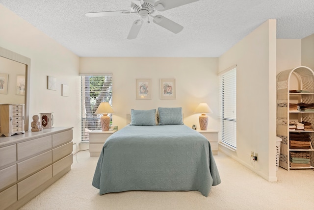 bedroom featuring a textured ceiling, ceiling fan, and light carpet