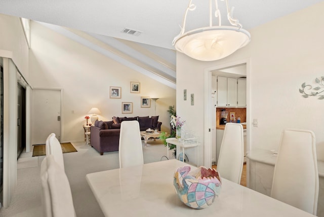 dining space featuring lofted ceiling, a chandelier, and light carpet