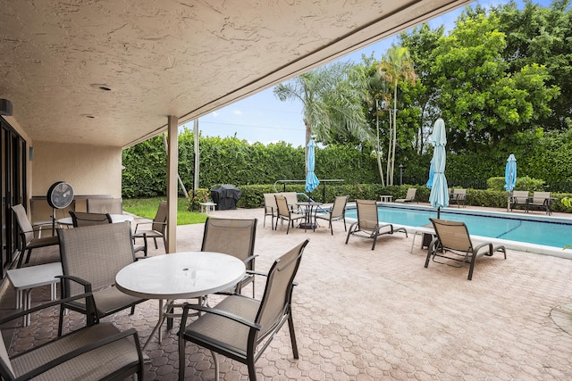 view of patio / terrace featuring outdoor dining area and an outdoor pool