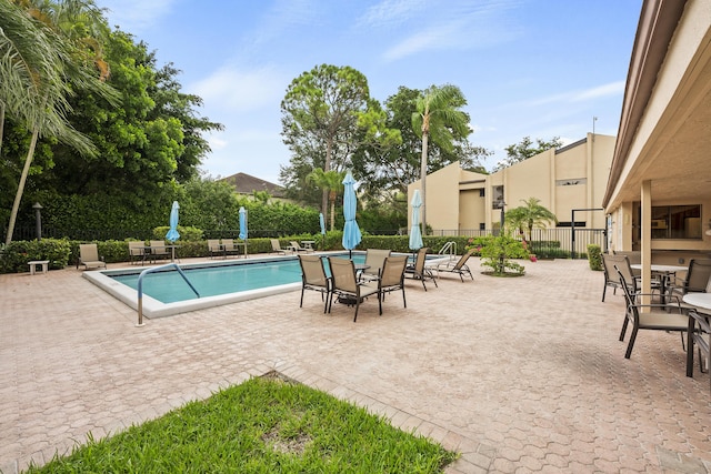 pool with a patio area and fence