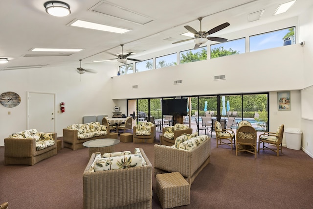 living area with dark colored carpet, visible vents, and plenty of natural light