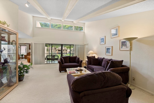 carpeted living room with beam ceiling, a textured ceiling, and a healthy amount of sunlight