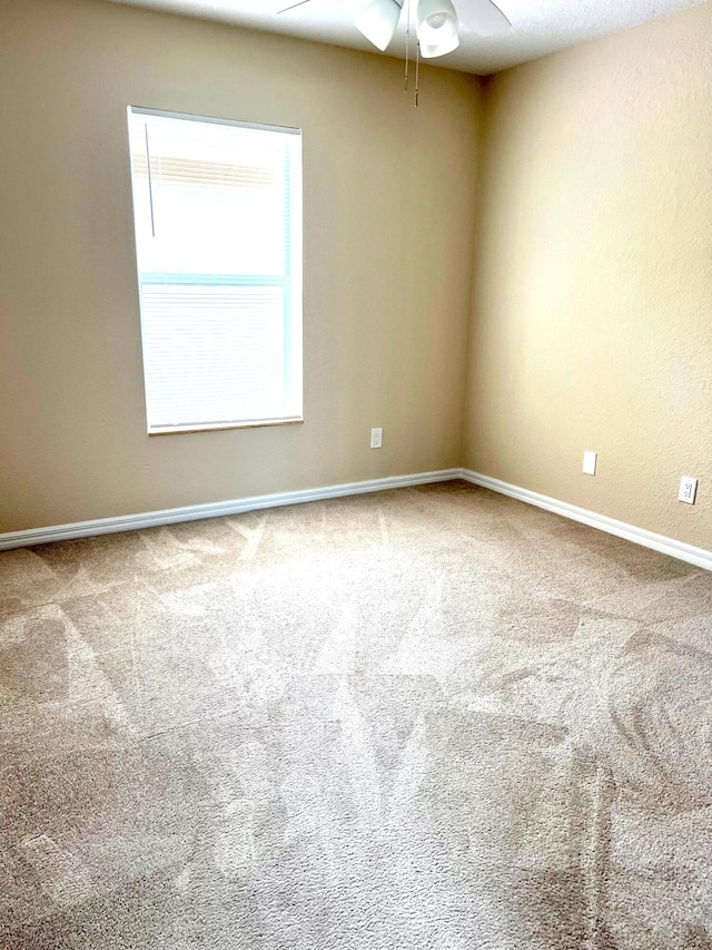 unfurnished room featuring ceiling fan and carpet flooring