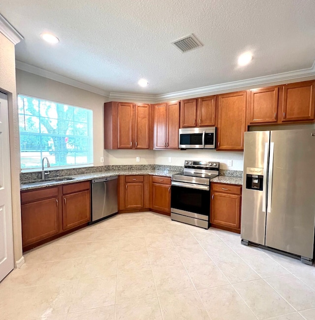 kitchen featuring sink, appliances with stainless steel finishes, a textured ceiling, light tile patterned floors, and crown molding