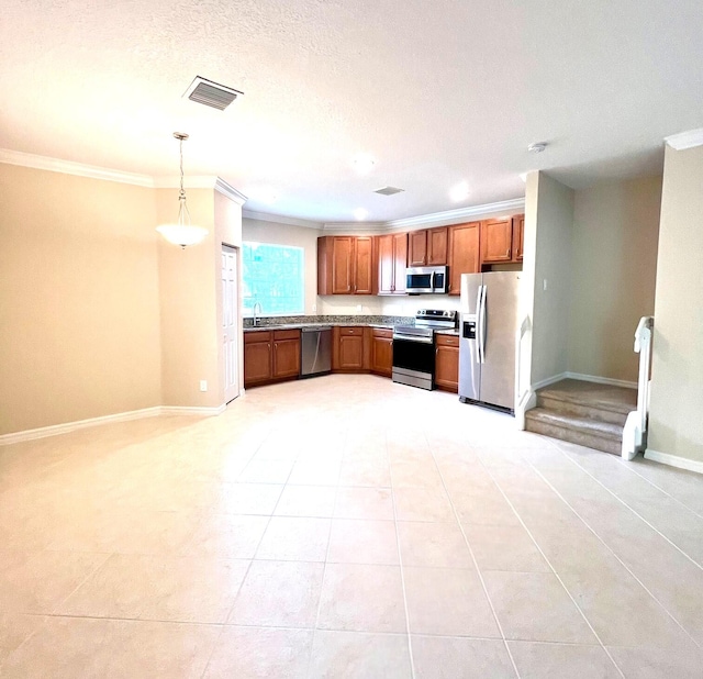 kitchen with hanging light fixtures, light tile patterned floors, crown molding, and stainless steel appliances