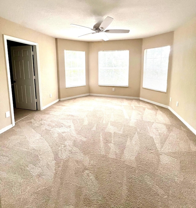 carpeted empty room featuring ceiling fan and a textured ceiling