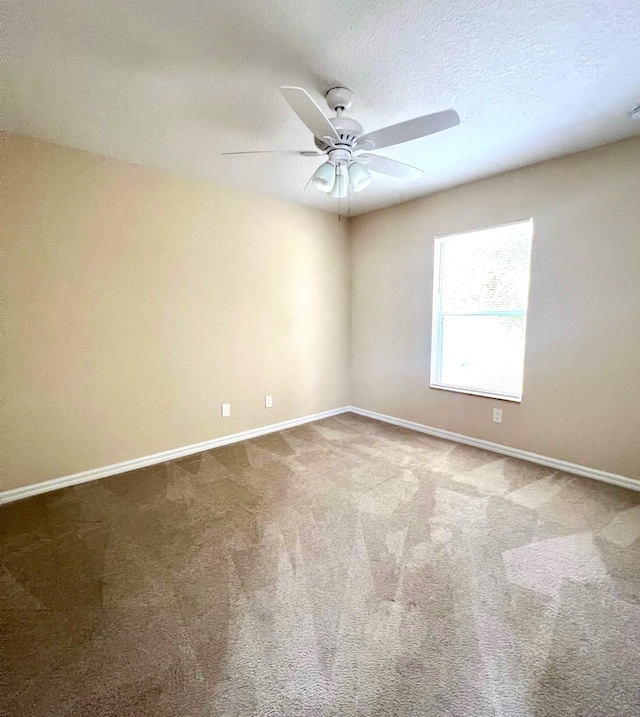 unfurnished room featuring ceiling fan, carpet flooring, and a textured ceiling