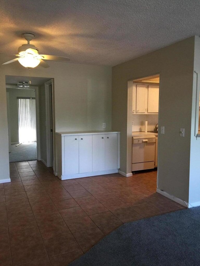 empty room with ceiling fan, dark carpet, and a textured ceiling