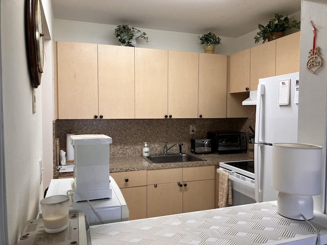 kitchen with a toaster, decorative backsplash, cream cabinets, a sink, and white appliances