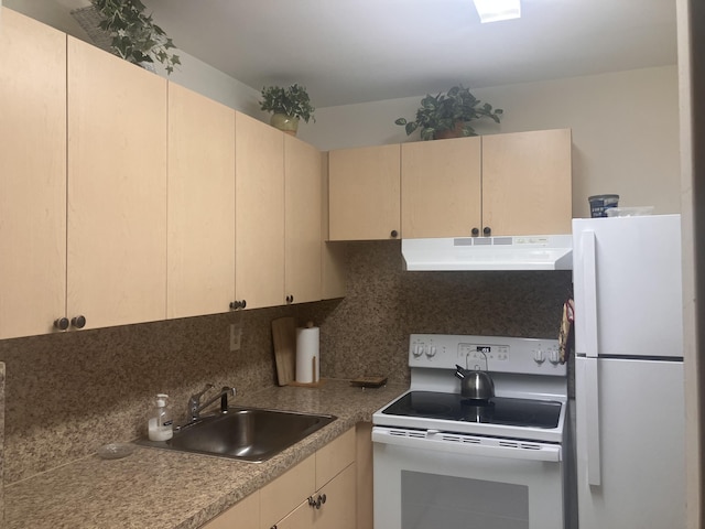 kitchen with white appliances, under cabinet range hood, cream cabinetry, tasteful backsplash, and a sink