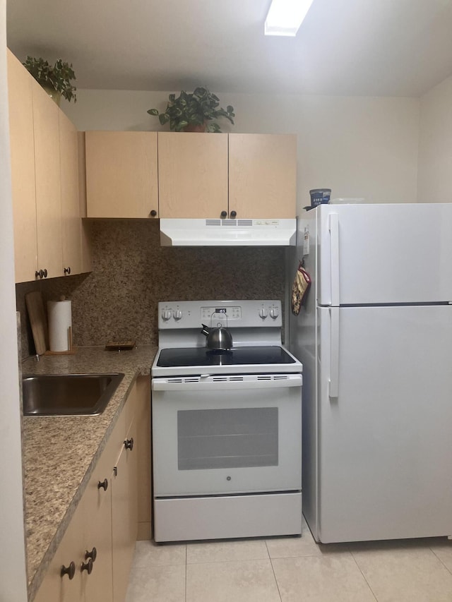 kitchen featuring decorative backsplash, light tile patterned flooring, white appliances, under cabinet range hood, and a sink