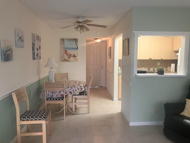 dining area with light tile patterned floors, baseboards, and a ceiling fan