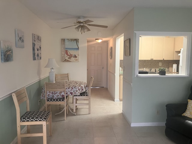 dining area featuring a ceiling fan, baseboards, and light tile patterned floors