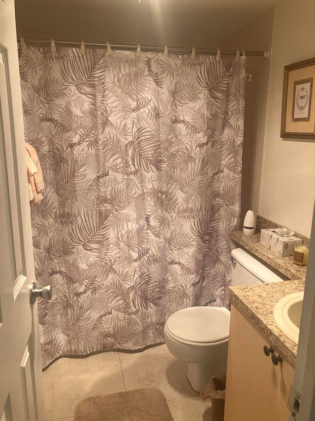 bathroom with a shower with curtain, vanity, toilet, and tile patterned floors