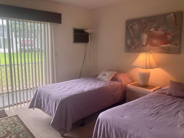 carpeted bedroom with multiple windows, a wall mounted AC, and access to exterior